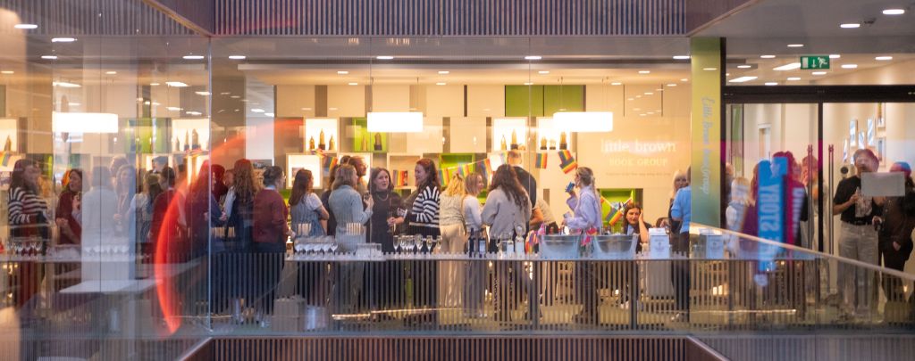 A close up of the London interior office - there is a gathering of staff with drinks